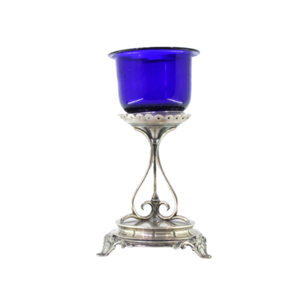Porta vela de altar em prata com alma em vidro azul assente em base circular com relevos e três pés com aplicações.